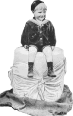 Photograph of a small boy on a huge Cheshire cheese